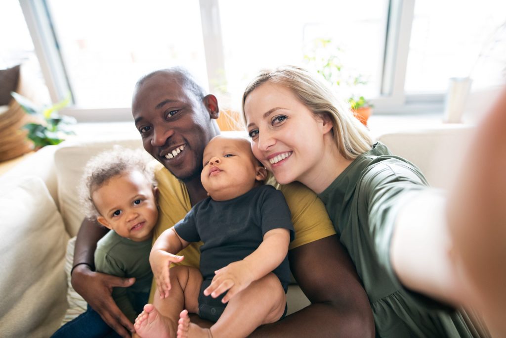 Young family with little children taking selfie.